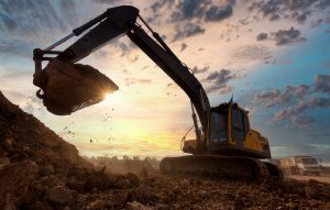 Industrial excavator loading tipper truck on construction site