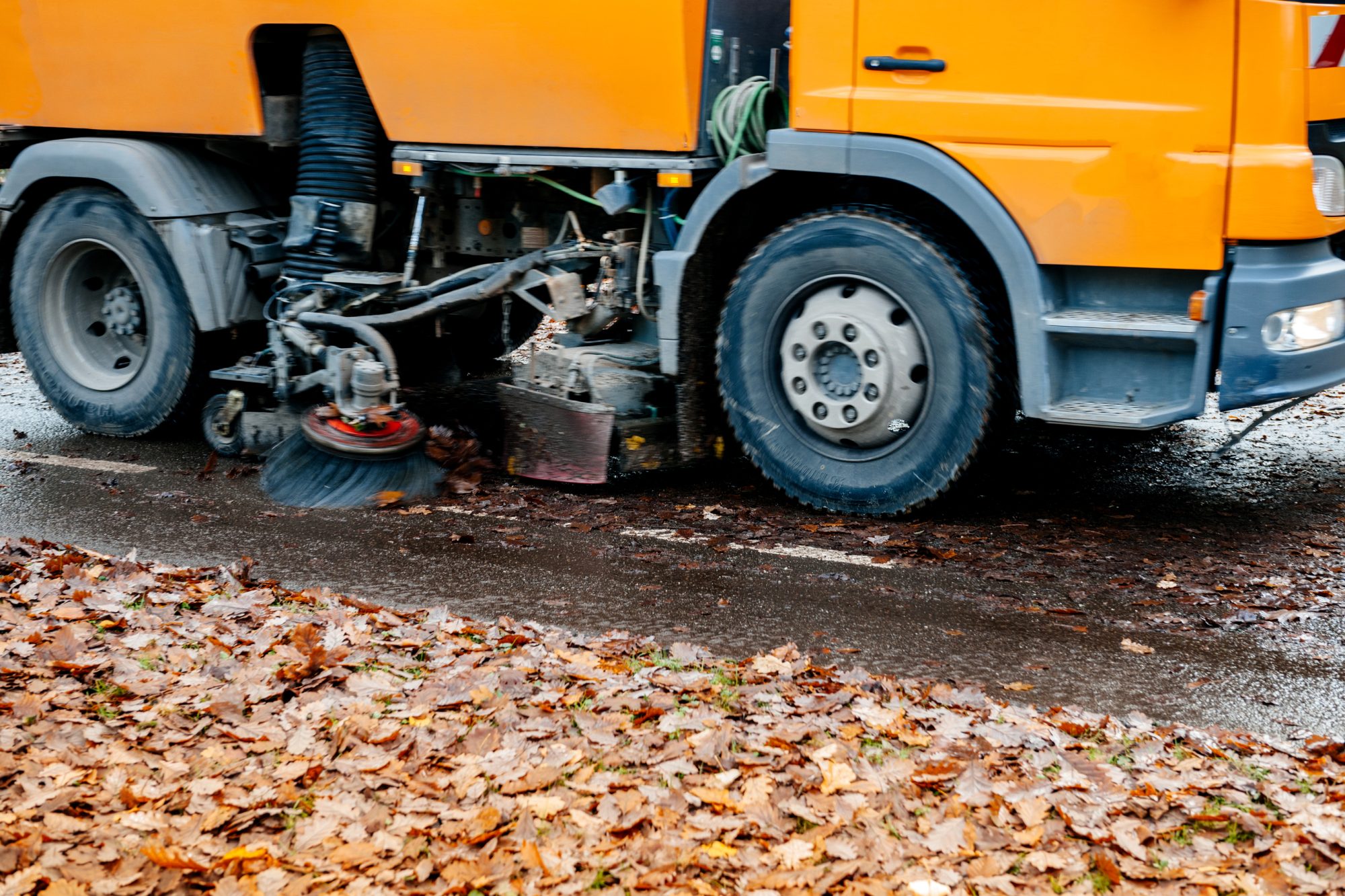 Modern street management with orange street sweeper truck